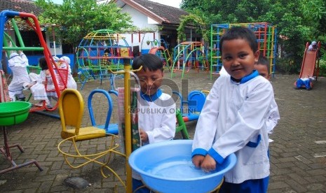 Anak menjaga kebersihan dengan mencuci tangan.