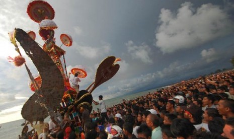 Anak nagari memanjat Tabuik di antara puluhan ribu warga menyaksikan prosesi Tabuik dibuang ke laut, di Pantai Gandoriah Pariaman, Sumbar, Minggu (25/11).