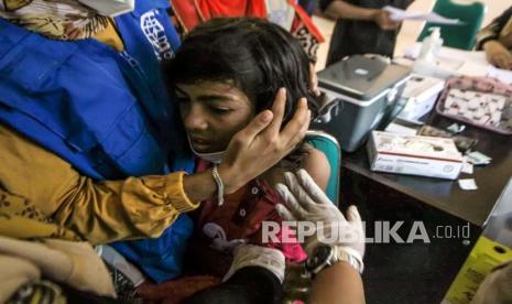 Anak pengungsi etnis Rohingya menjalani vaksinasi COVID-19 dosis kedua di tempat penampungan sementara BLK Desa Meunasah Mee Kandang, Muara Dua, Lhokseumawe, Aceh, Jumat (18/2/2022). Sebanyak 67 orang dari total 108 pengungsi Rohingya yang ditampung sejak 31 Desember 2021 itu dilaporkan telah melarikan diri dari BLK.