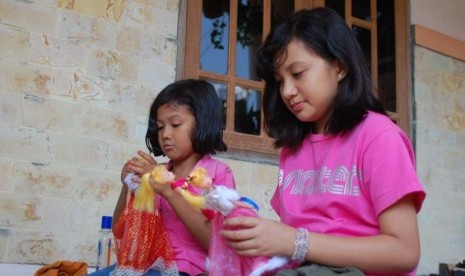 Anak perempuan yang sedang bermain boneka (ilustrasi).