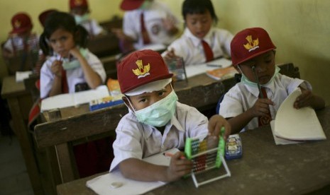   Anak sekolah memakai masker untuk melindungi pernapasan mereka dari abu vulkanis letusan Gunung Sinabung, di sebuah sekolah dasar di Kabupaten Karo, Sumatera Utara, Selasa (17/9).     (AP/Binsar Bakkara)