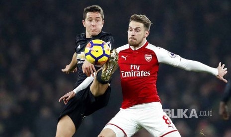 Ander Herrera (kiri) berebut bola dengan Aaron Ramsey (kanan) pada pertandingan Liga Inggris di Emirates Stadium, London, Ahad (3/12) dini hari.