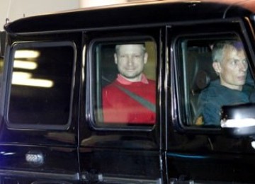 Anders Breivik, tersenyum saat berada di dalam mobil polisi