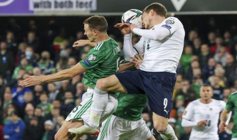 Andrea Belotti dari Italia (kanan) dan Jonny Evans dari Irlandia Utara bersaing memperebutkan bola dalam pertandingan sepak bola kualifikasi grup C Piala Dunia 2022 antara Irlandia Utara dan Italia di stadion Windsor Park di Belfast, Irlandia Utara, Selasa (16/11).