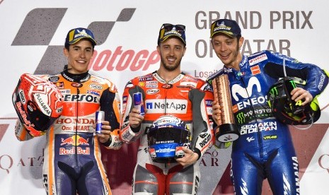 Andrea Dovizioso (tengah), Marc Marquez (kiri), dan Valentino Rossi (kanan) di podium GP Qatar, Ahad (18/3).