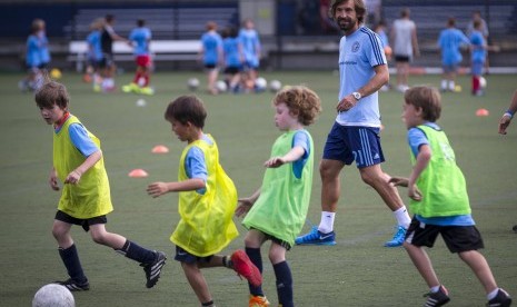 Andrea Pirlo bermain bersama anak-anak ketika menyambangi tempat latihan sepak bola usai diperkenalkan sebagai pemain anyar New York City FC di New York