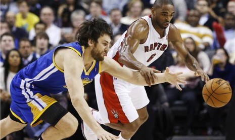 Andrew Bogut (kiri), center Golden State Warriors, berebut bola dengan pemain Toronto Raptors, Alan Anderson, di pertandingan NBA di Toronto pada 28 Januari. 