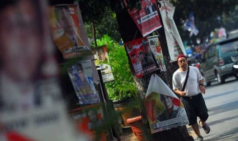 Aneka poster partai yang ditempel di pohon.