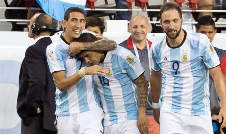 Angel Di Maria (kiri) memeluk Ever Banega yang mencetak gol kemenangan Argentina atas Cile.