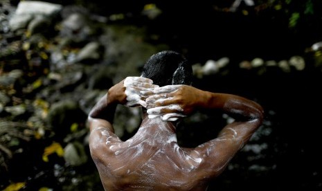 Angel Sanchez mandi di sungai Taman Nasional El Avila di Caracas, Venezuela,Rabu (3/4). Akibat krisis air, warga menyerbu kawasan hutan tersebut.