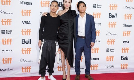 Angelina Jolie (tengah) diapit putranya Maddox (kiri) dan Pax (kanan). 