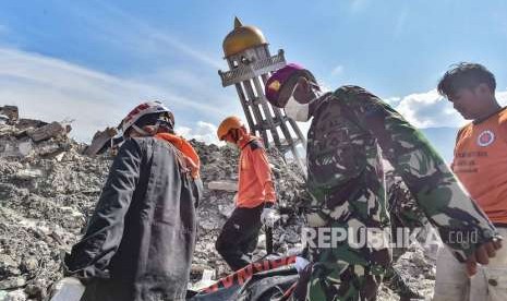 Anggota Basarnas bersama TNI dan relawan membawa kantong berisi jenazah korban gempa dan tsunami di Balaroa, Palu, Sulawesi Tengah, Kamis (4/10). 