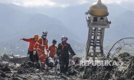 Anggota Basarnas bersama TNI dan relawan membawa kantong berisi jenazah korban gempa dan tsunami di Balaroa, Palu, Sulawesi Tengah, Kamis (4/10). 