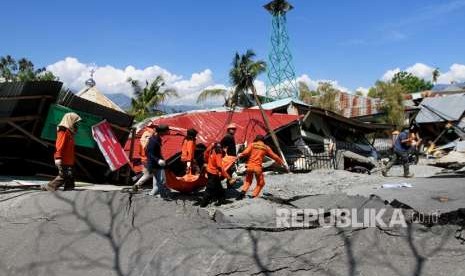 Anggota Basarnas mengevakuasi jenazah korban gempa di Petabo, Palu Selatan, Sulawesi Tengah, Senin (1/10). 