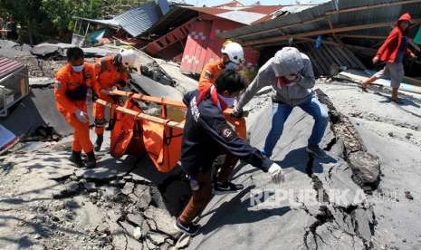 Anggota Basarnas mengevakuasi jenazah korban gempa di Petabo, Palu Selatan, Sulawesi Tengah, Senin (1/10).