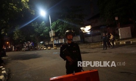 Anggota Brimob berjaga di sekitar tempat kejadian perkara penikaman anggota polisi di depan Masjid Falatehan,Jakarta Selatan, Jumat (30/6)