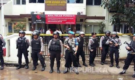 Anggota Brimob  berjaga mengamankan Kantor Kelurahan Arjuna, Pasca pelaku peledakan dibawa menggunakan Ambulance, Jalan Ajuna, Kota Bandung, Senin (27/2).