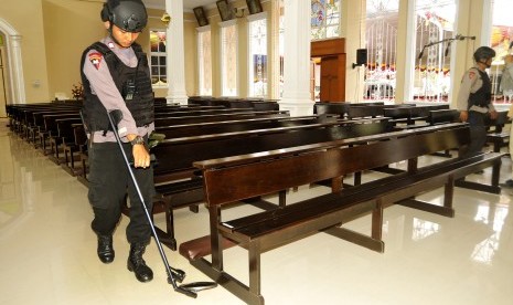 Anggota Brimob Polda Banten menyisir tempat duduk jemaah dengan metal detektor di Gereja Kristus Sang Raja di Serang, Banten, Sabtu (24/12). 