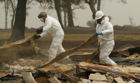 Anggota California Army National Guard mencari korban di sisa rumah yang terbakar di Paradise, Kalifornia, akibat kebakaran hutan, Rabu (14/11).