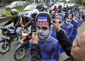 Anggota dari Laskar KPK mengenakan topeng bergambar Nazaruddin saat melakukan aksi teatrikal di depan Komisi Pemberantasan Korupsi, Jakarta, Jumat (10/6).