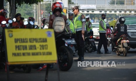  Anggota dari Polres Metro Jakarta Selatan memberhentikan pengendara motor saat menggelar Operasi Patuh Jaya di Kawasan Stasiun Pasar Minggu, Jakarta, Jumat (12/5). 