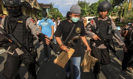 Anggota Datasemen Khusus (Densus) 88 antiteror Mabes Polri membawa barang bukti milik terduga teroris jaringan Nur Rohman, Haryanto alias Hasan di Makam Haji, Sukoharjo, Jawa Tengah, Selasa (19/7).