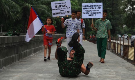 Anggota Detasemen Polisi Militer IV/4 Solo, Kopral Kepala (Cpm) Partika Subagyo Lelono beserta sejumlah anak menggelar Aksi Tolak Narkoba dan LGBT di Solo, Jawa Tengah, Rabu (24/2). 