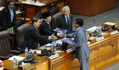 Anggota Dewan Perwakilan Rakyat (DPR) Fraksi Partai Nasdem, Jhonny G Plate menyerahkan pandangan fraksi terhadap nota keuangan RPABN 2016 kepada Wakil Ketua DPR Taufik Kurniawan (tengah) saat mengikuti rapat paripurna di Gedung Nusantara II, Kompleks Parle