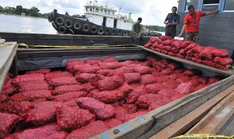 Anggota Ditpolair Polda Jambi memeriksa barang bukti tangkapan bawang merah selundupan saat akan diamankan ke Markas Unit Patroli Angsoduo Ditpolair Polda Jambi di tepian Sungai Batanghari, Kasang, Jambi, Senin (25/4). 