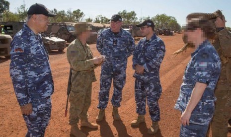   Anggota DPR Australia Scott Buchholz (tengah) saat melakukan kunjungan ke markas militer. Dia mengakui bertindak tak senonoh terhadap seorang anggota militer dalam kunjungan itu. 