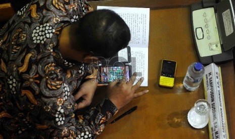 Anggota DPR bermain game di smartphone saat mengikuti sidang paripurna di Kompek Parlemen, Jakarta, Senin (23/3).