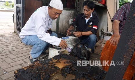 Anggota FPI melihat barang yang terkena lemparan bom molotov di Posko FPI DPC Pasar Rebo, Jakarta, Kamis (2/2).