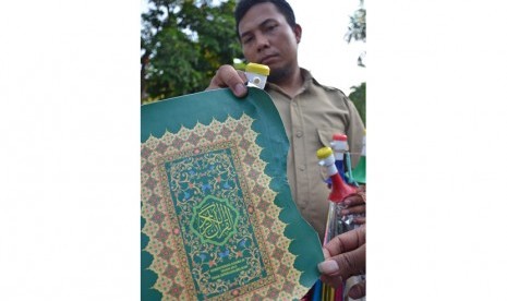 Anggota Intel Korem 162/Wira Bhakti menunjukkan kertas bahan terompet sampul Al Quran bertuliskan Kementrian Agama RI Tahun 2013 saat diamankan di Kantor Intel Korem 162/Wira Bhakti Mataram, NTB, Selasa (29/12). 