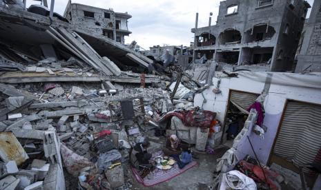 Anggota keluarga Al-Rabaya berbuka puasa selama bulan suci Ramadhan di luar rumah mereka yang hancur akibat serangan udara Israel di Rafah, Jalur Gaza, Senin, 18 Maret 2024. 