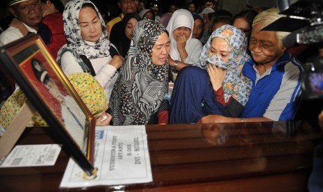 Anggota keluarga Copilot Aviastar almarhum Yudhistira Febby Aryanto menangis di samping peti jenazah setibanya di Masjid Nurul Huda, Kawasan Bandara Ngurah Rai, Denpasar, Kamis (8/10).