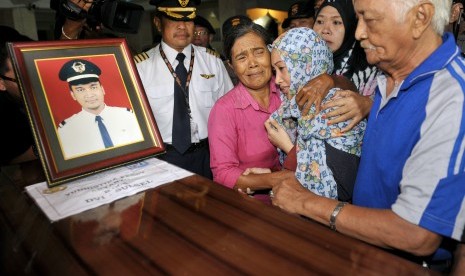 Anggota keluarga Copilot Aviastar almarhum Yudhistira Febby Aryanto menangis di samping peti jenazah setibanya di Masjid Nurul Huda, Kawasan Bandara Ngurah Rai, Denpasar, Kamis (8/10). 