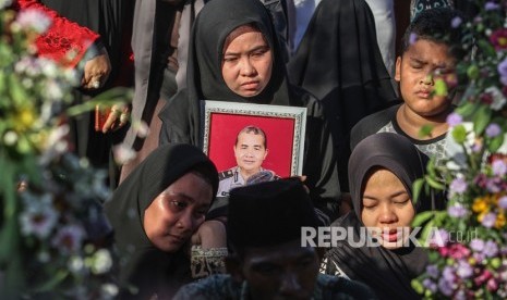 Anggota keluarga Ipda Auzar yang menjadi korban penyerangan Mapolda Riau menangis ketika acara pemakaman di Pekanbaru, Riau, Rabu (16/5). 