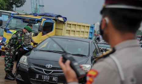 Anggota Kepolisian dan TNI memeriksa surat keterangan sehat dari pengendara luar Bandung saat operasi PPKM Mikro di Gerbang Keluar Tol Cileunyi, Kabupaten Bandung, Jawa Barat, Jumat (18/6/2021). Penyekatan kendaraan dari luar Bandung tersebut dilakukan setelah Jawa Barat dinyatakan siaga satu COVID-19 serta ditujukan untuk mencegah penyebaran COVID-19 di wilayah Bandung Raya.