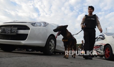 Anggota kepolisian dari Divisi K-9 melakukan patroli pengamanan dengan anjing pelacak narkotika di Pelabuhan Merak, Banten, Jumat (1/7).