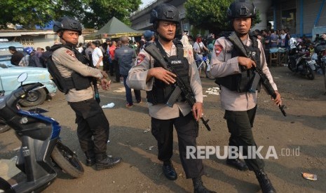 Anggota Kepolisian dengan senjata lengkap berjaga di sekitar Tempat Kejadian Perkara (TKP) dugaan bom bunuh diri di Terminal Kampung Melayu, Jakarta Timur, Rabu (25/5). 