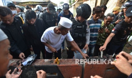 Anggota Kepolisian dibantu oleh warga mengumpulkan serpihan tubuh korban di sekitar Tempat Kejadian Perkara (TKP) dugaan bom bunuh diri di Terminal Kampung Melayu, Jakarta Timur (Ilustrasi)