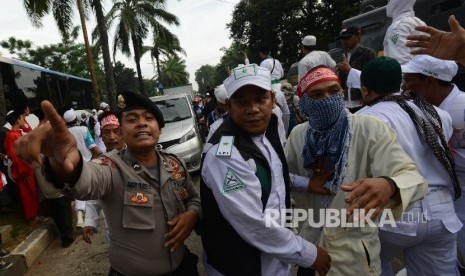 Anggota kepolisian melerai Massa GNPF MUI yang terlibat adu mulut dengan massa pendukung ahok melakukan aksi kawal sidang ahok dengan agenda pemeriksaan saksi di Auditorium Kementerian Pertanian, Jakarta Selatan, Selasa (3/1).