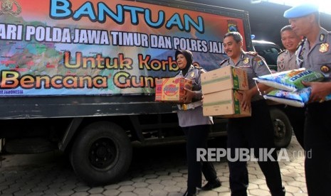 Anggota kepolisian membawa bantuan yang akan didistribusikan kepada pengungsi korban Gunung Agung di Mapolres Banyuwangi, Jawa Timur, Kamis (30/11). 