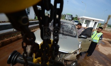  Anggota kepolisian memeriksa mobil yang telah mengalami kecelakaan di KM 104 ruas Jalan Tol Cipali, Subang, Jawa Barat, Jumat (10/7).  (Republika/Raisan Al Farisi)