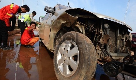  Anggota kepolisian memeriksa mobil yang telah mengalami kecelakaan di KM 104 ruas Jalan Tol Cipali, Subang, Jawa Barat, Jumat (10/7).  (Republika/Raisan Al Farisi)