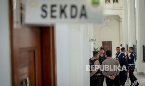 Anggota kepolisian menjaga ruangan Sekda Jabar non aktif Iwa Karniwa saat penggeledahan oleh penyidik KPK di Gedung Sate, Bandung, Jawa Barat, Rabu (31/7/2019). 