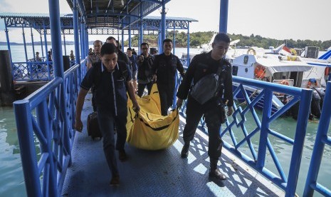 Anggota kepolisian Polda Kepri mengangkat kantong jenazah yang berisikan barang-barang yang diduga milik korban jatuhnya pesawat M28 Skytruck Pelabuhan Telaga Punggur, Batam, Kepulauan Riau, Minggu (4/12). 