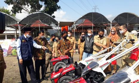 Anggota Komisi IV DPR RI drh Slamet menyerahkan bantuan hand traktor dari pemerintah pusat kepada kelompok tani dan disaksikan Wali Kota Sukabumi Achmad Fahmi di Sub Stasiun Agribisnis (STA) Bungbulang, Kecamatan Cibeureum, Senin (27/7).