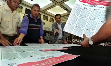  Anggota Komisi Pemilihan Umum (KPU) Arief Budiman (kedua kiri), anggota KPU Sigit Pamungkas (ketiga kiri) mengecek dummy surat suara saat penandatanganan draft oleh partai politik di kantor KPU, Jakarta, Selasa (3/12).     (Republika/ Tahta Aidilla)  