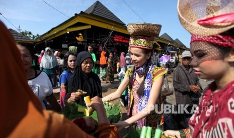 Anggota Komunitas membagikan kue tradisional kepada pengunjung pasar Kenanga saat pembukaan Festival Pasar Rakyat di Pontianak, Kalimantan Barat, Sabtu (22/7). 